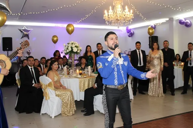 Mariachi con traje azul cantando en evento elegante salón Bogotá
