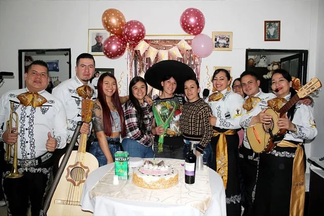 Mariachi con traje blanco y negro en cumpleaños de mamá con hijas en casa Bogotá