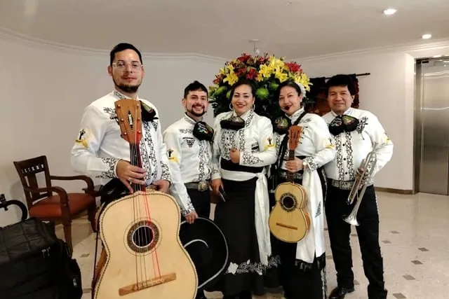 Mariachi con traje blanco y negro en hotel elegante Bogotá