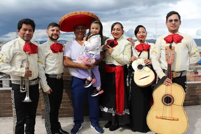 Mariachi con traje blanco y negro en serenata para papá con hija en azotea Bogotá sur