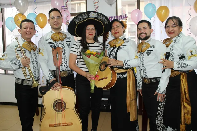 Mariachi con traje blanco y negro en serenata sorpresa en oficina Bogotá
