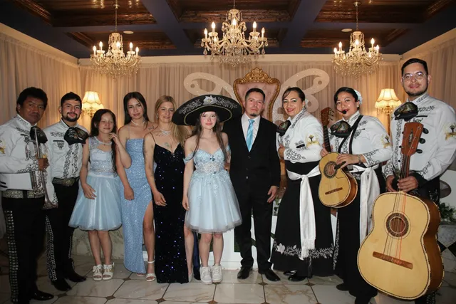 Mariachi con traje blanco y negro en quinceañera con familia en lugar elegante Bogotá