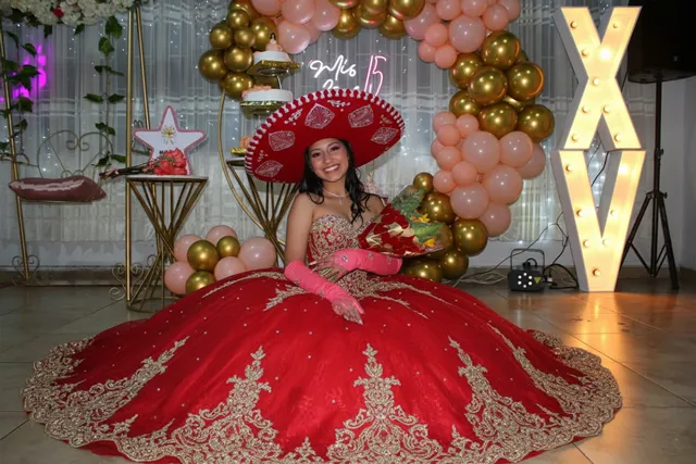 Quinceañera con vestido rojo luciendo su celebración con sombrero de charro Bogotá